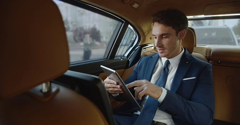 smiling-male-professional-reading-good-news-tablet-computer-automobile